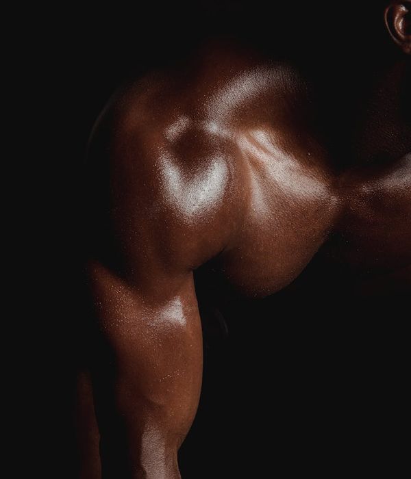 Man performing a controlled strength exercise in a dark gym with aqua light.